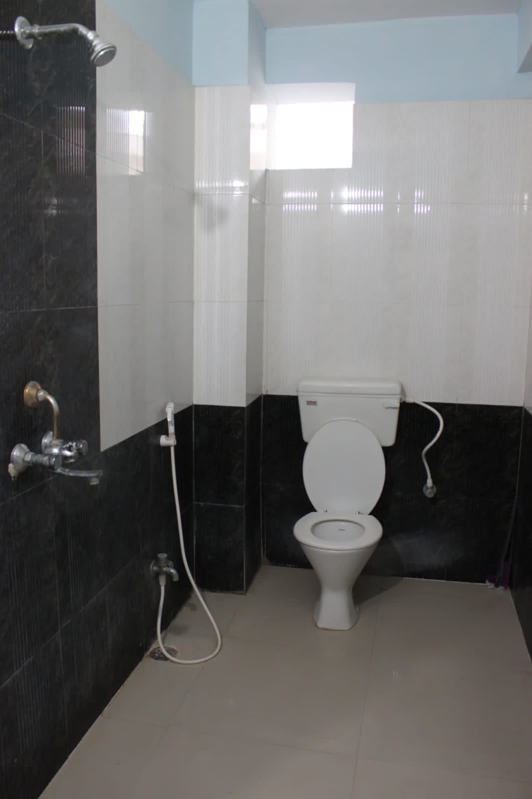 Clean tiled guest bathroom with shower at Happy International Guest House