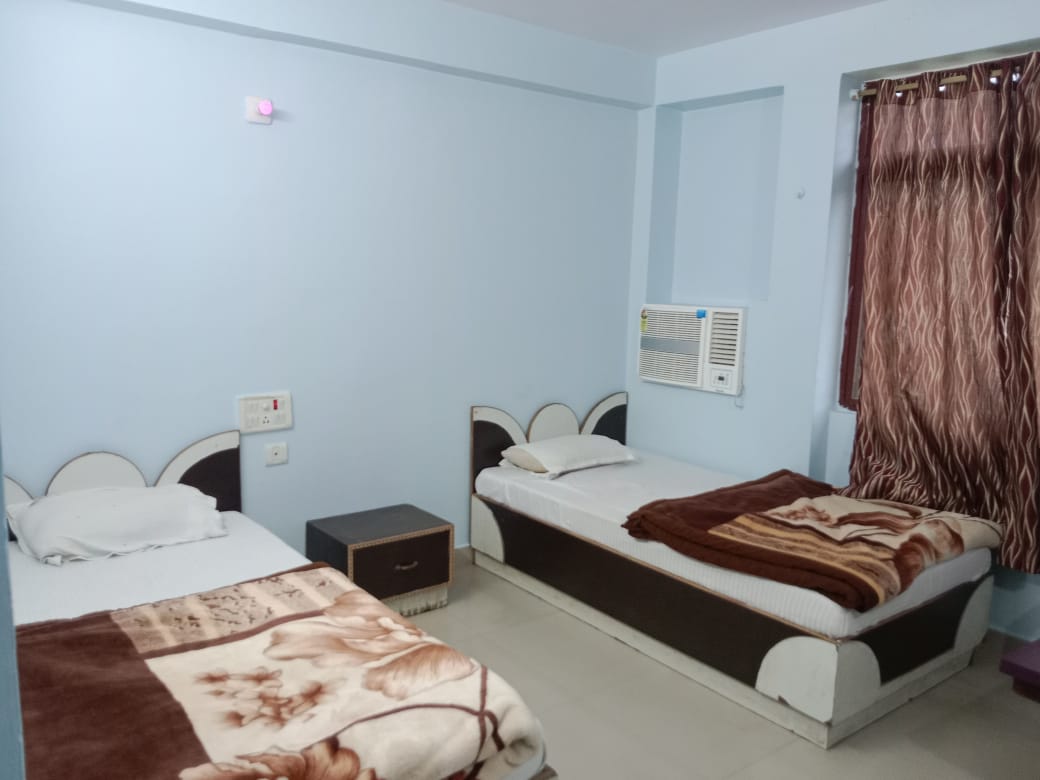 AC room with two separate single beds at Happy International Guest House